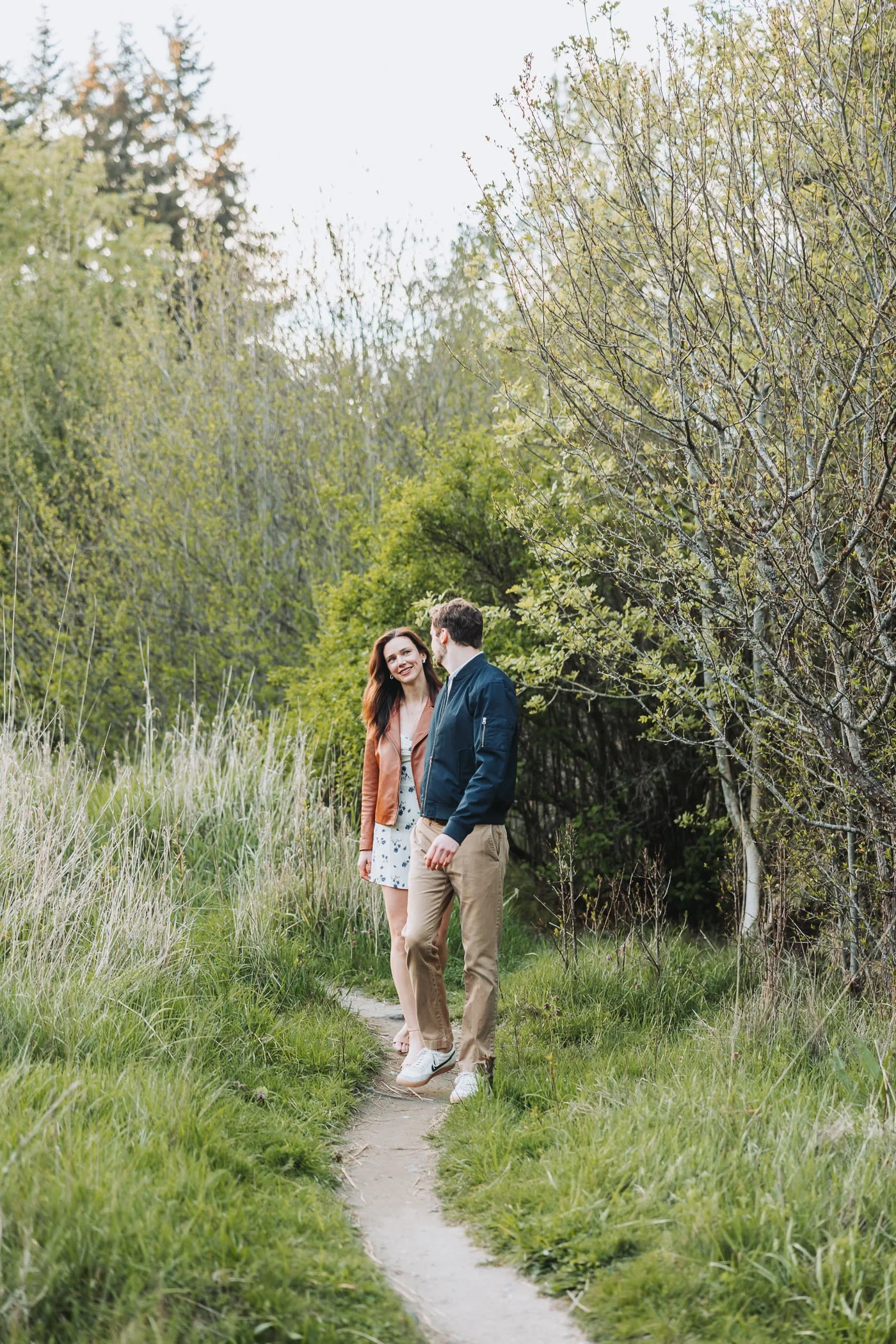 Couple walking on a narrow trail at Discovery Park in Seattle, WA