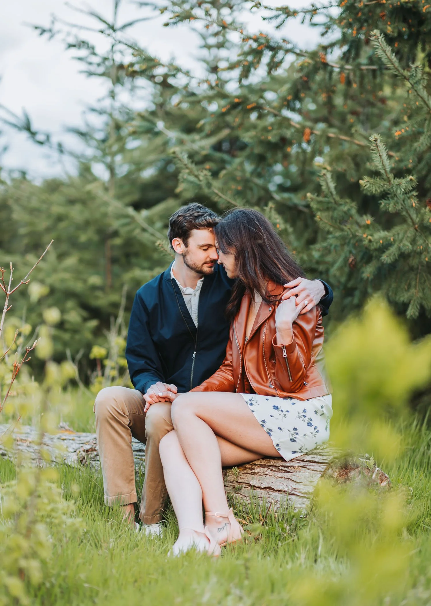 Romanic couple sitting on a log at Discovery Park in Seattle, WA