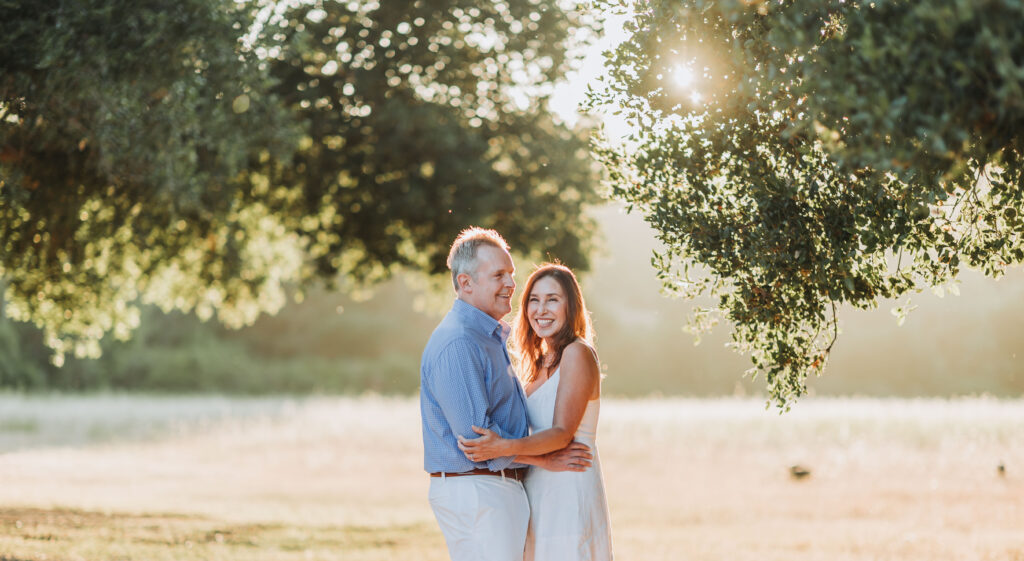Engaged couple with dramatic light from the sun coming through leaves at Rancho San Antonio in Cupertino, CA