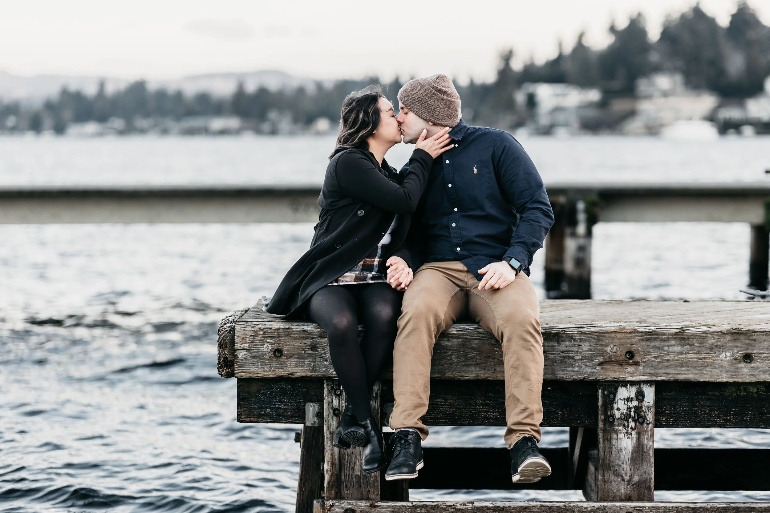 Couple sitting on the dock at Luther Burbank Park on Mercer Island, WA