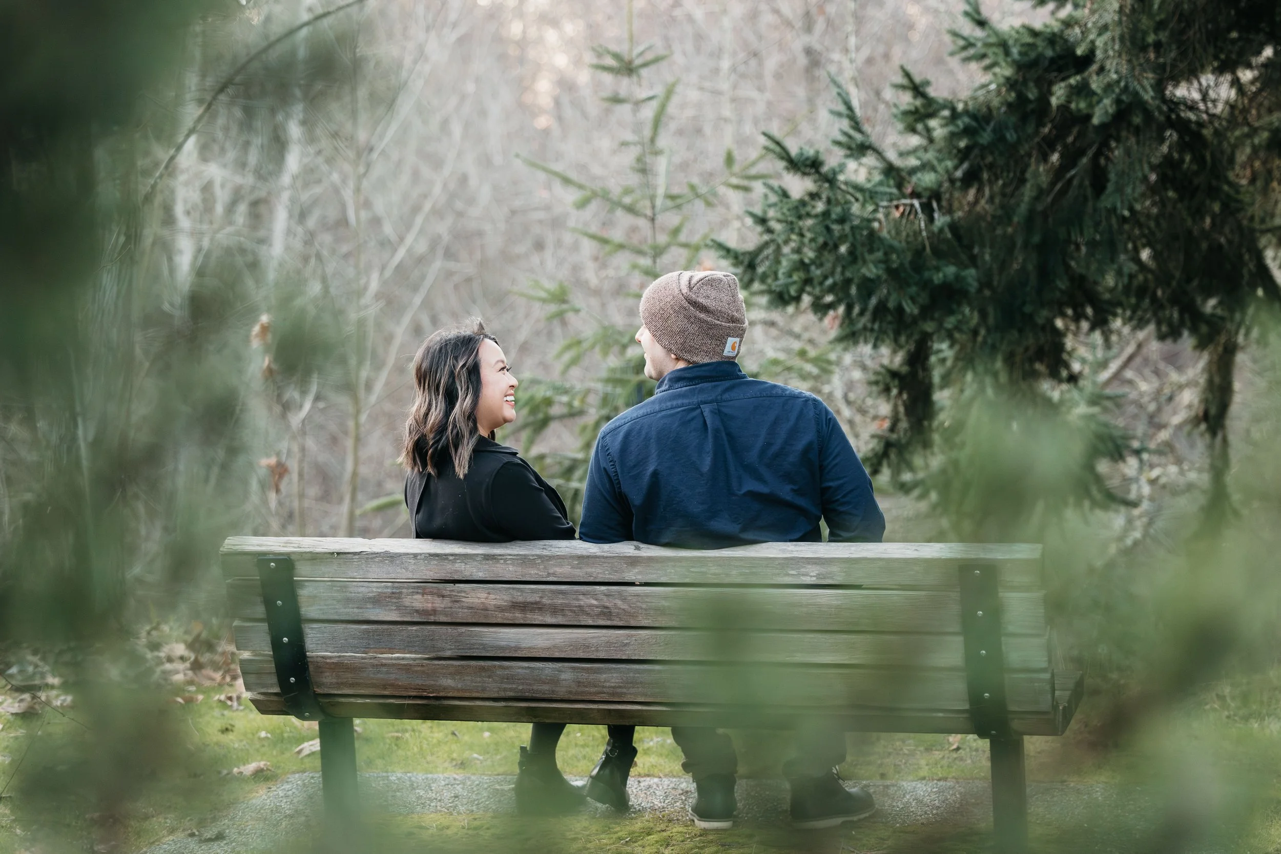 Couple sitting on a bench at Luther Burbank Park on Mercer Island, WA